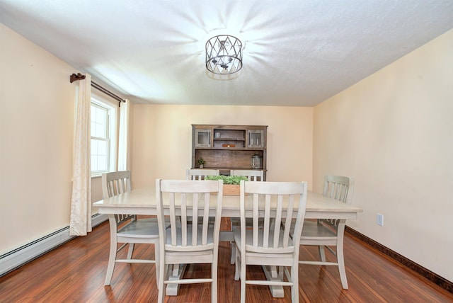 dining space with dark wood-type flooring, baseboards, a textured ceiling, and baseboard heating