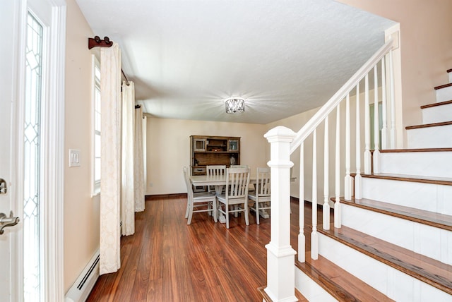 interior space with a baseboard radiator, stairway, and wood finished floors