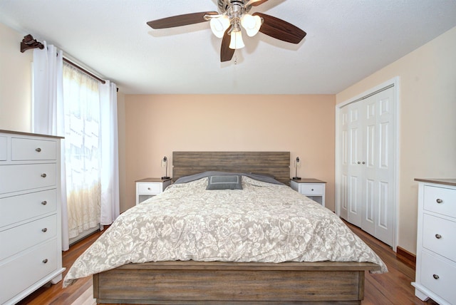 bedroom with dark wood-style floors, a closet, and a ceiling fan