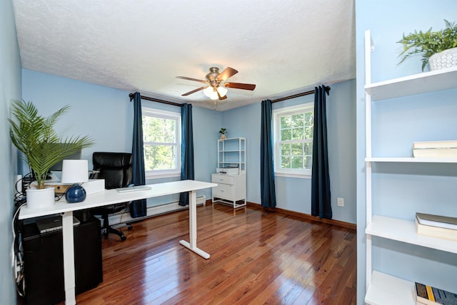 home office with a healthy amount of sunlight, wood-type flooring, ceiling fan, and a textured ceiling