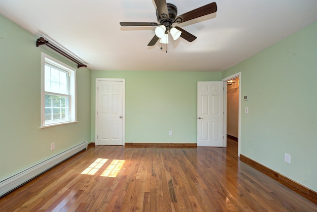 unfurnished bedroom with a ceiling fan, a baseboard radiator, baseboards, and wood finished floors