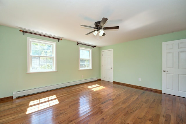 empty room with a ceiling fan, a baseboard radiator, baseboards, and wood finished floors