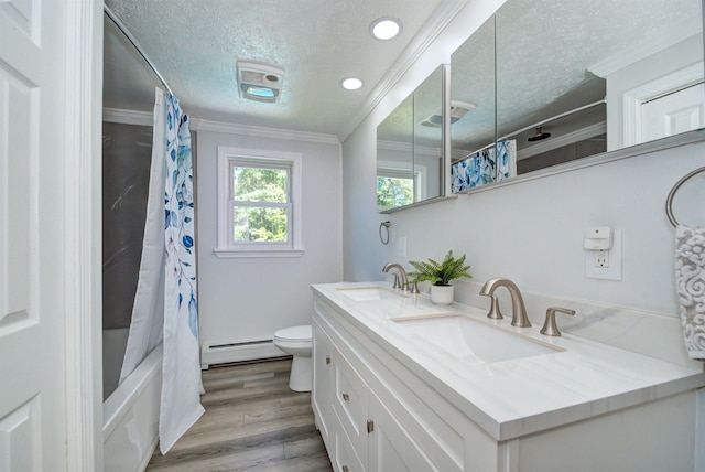 bathroom featuring crown molding, toilet, a sink, and baseboard heating