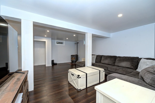 living area featuring a wood stove, baseboards, dark wood-type flooring, and recessed lighting