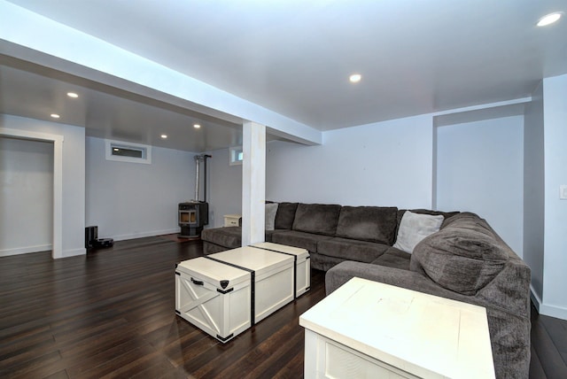 living area featuring a wood stove, baseboards, dark wood-type flooring, and recessed lighting