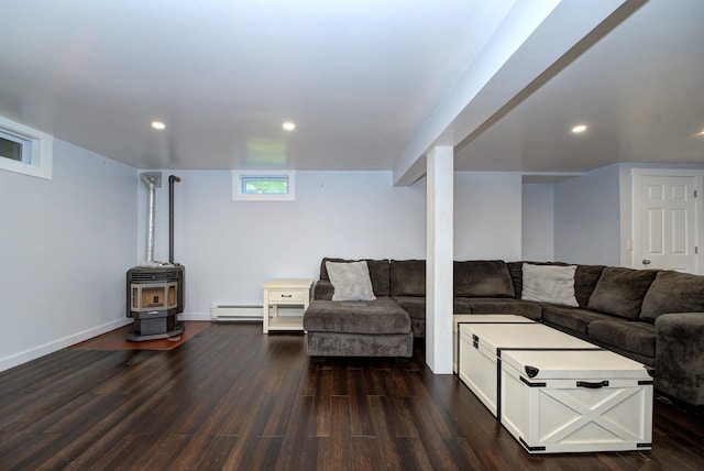 living area featuring dark wood-style floors, a baseboard heating unit, a wood stove, and recessed lighting