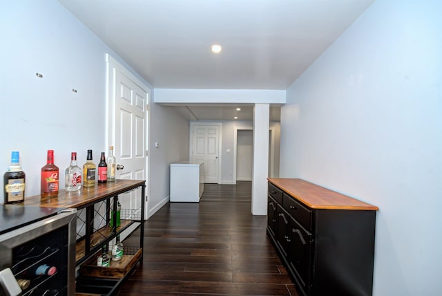 hall featuring baseboards and dark wood finished floors