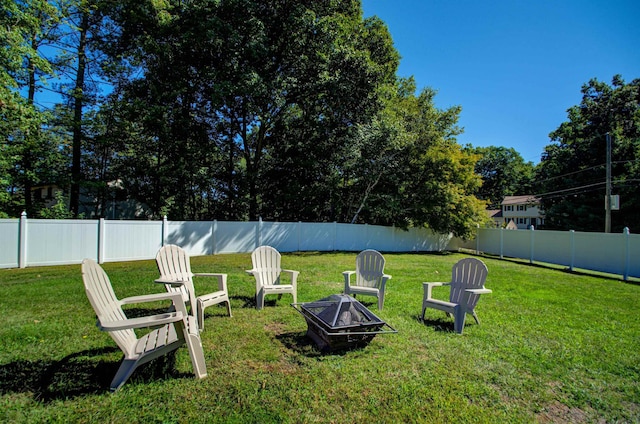 view of yard featuring a fenced backyard and a fire pit