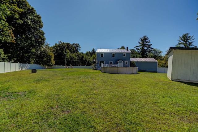 view of yard featuring an outbuilding, a fenced backyard, and a fenced in pool