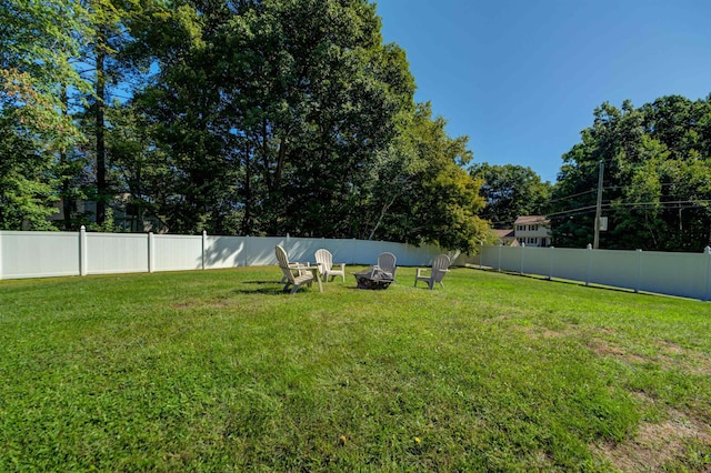 view of yard featuring a fenced backyard and a fire pit