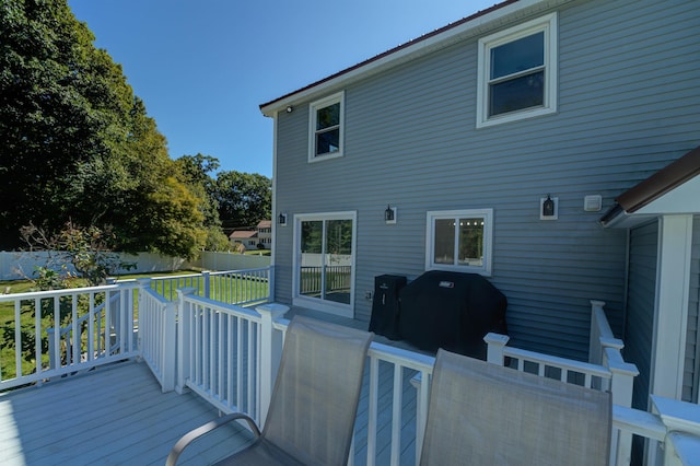 wooden deck featuring a grill and fence