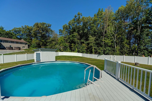 view of pool with an outbuilding, a yard, a shed, and a fenced backyard