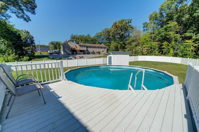 view of swimming pool with a lawn, a fenced backyard, a wooden deck, and a fenced in pool