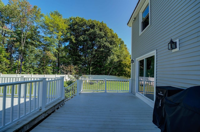 deck with a grill and a fenced backyard