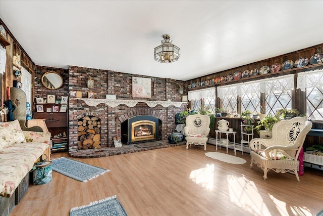 interior space with a brick fireplace and wood finished floors