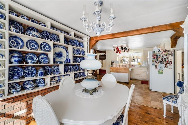 dining space featuring beam ceiling and a notable chandelier