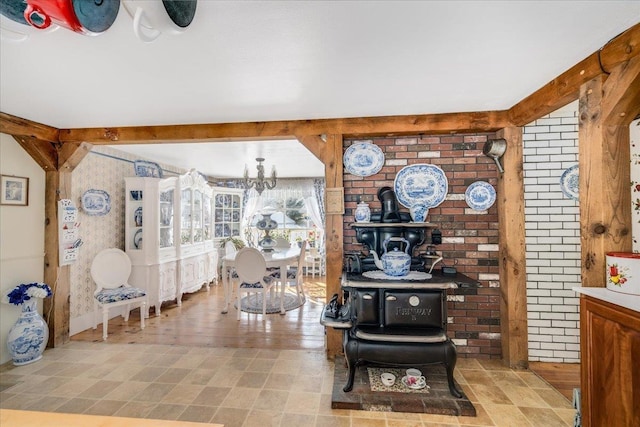 interior space featuring a wood stove, a notable chandelier, and beamed ceiling