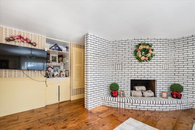 living area with hardwood / wood-style floors and a brick fireplace