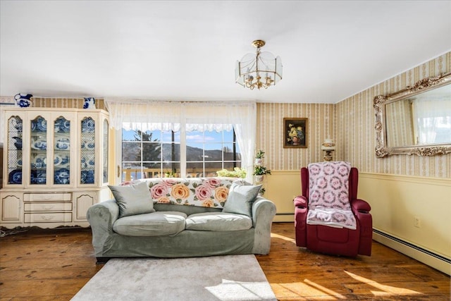 living room featuring wainscoting, wood finished floors, a baseboard radiator, and wallpapered walls