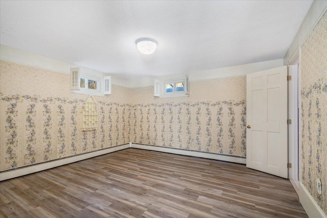 spare room featuring a textured ceiling and wood finished floors