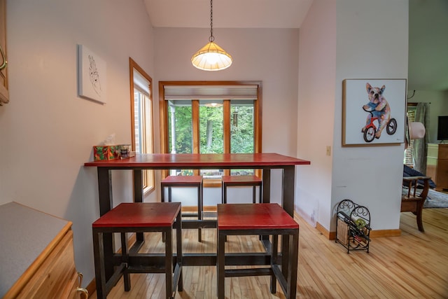 dining space with light wood-type flooring and baseboards