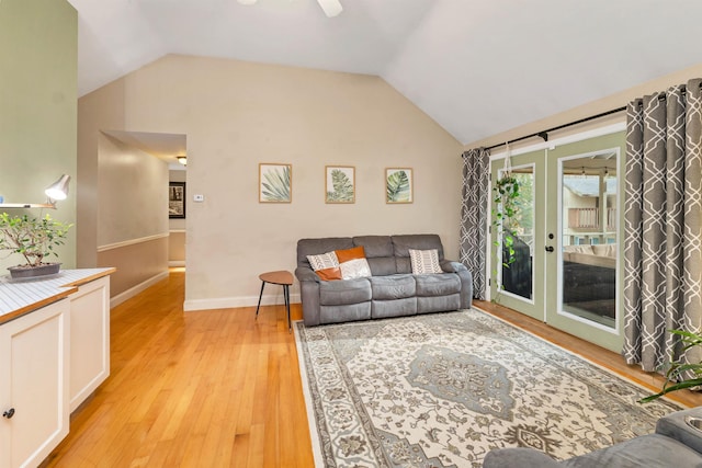 living room featuring french doors, baseboards, vaulted ceiling, and light wood finished floors