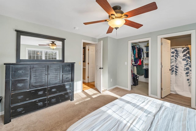 bedroom featuring carpet floors, a walk in closet, a closet, and baseboards