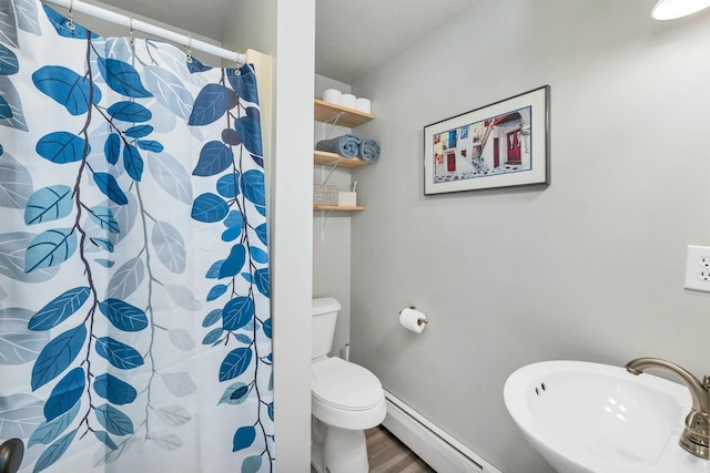 full bathroom with a shower with shower curtain, toilet, wood finished floors, a baseboard heating unit, and a sink