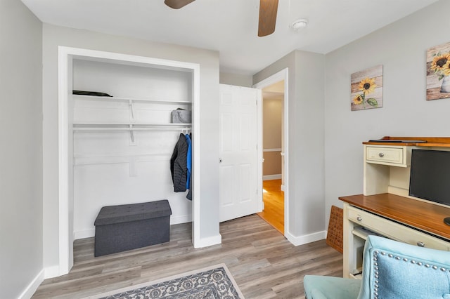 interior space with light wood-type flooring, ceiling fan, baseboards, and a closet