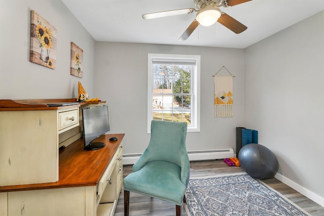 office area with baseboards, a baseboard heating unit, ceiling fan, and wood finished floors