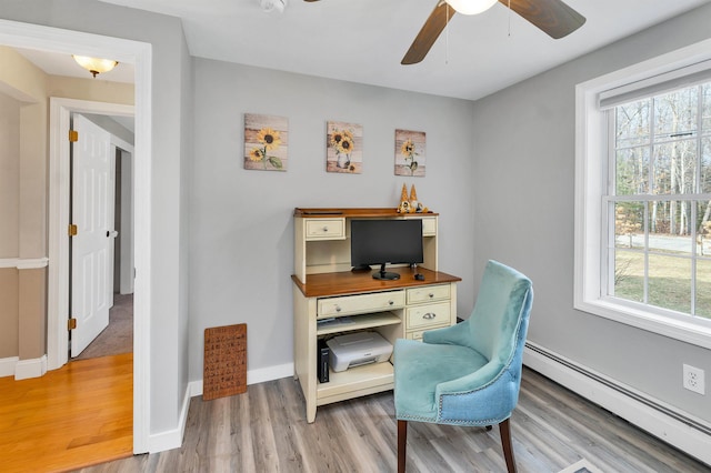 office featuring a wealth of natural light, a baseboard radiator, baseboards, and wood finished floors