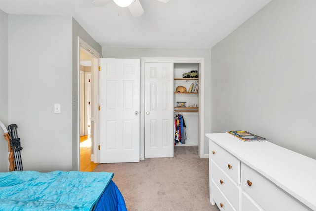 bedroom featuring a ceiling fan, a closet, and light colored carpet