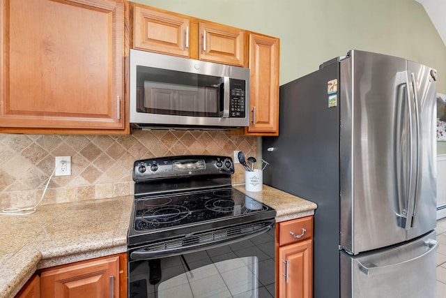 kitchen with tasteful backsplash, tile patterned flooring, stainless steel appliances, and light countertops