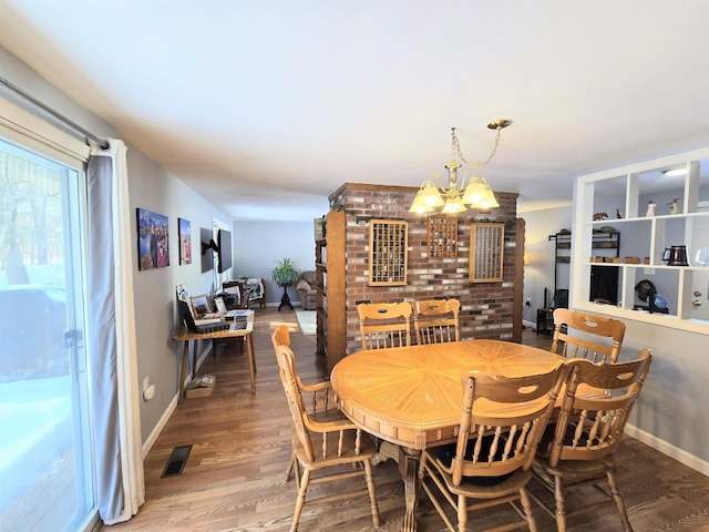 dining area featuring an inviting chandelier, baseboards, visible vents, and wood finished floors