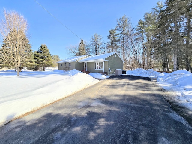 view of front of home featuring driveway and central air condition unit