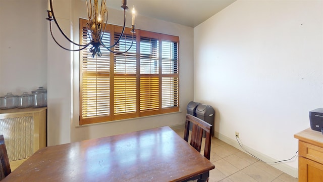 dining area with tile patterned flooring, a chandelier, and baseboards