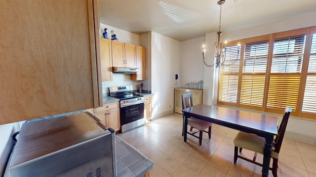 kitchen featuring stainless steel electric range oven, light tile patterned floors, light brown cabinets, a chandelier, and under cabinet range hood