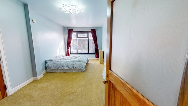 bedroom with baseboards and light colored carpet