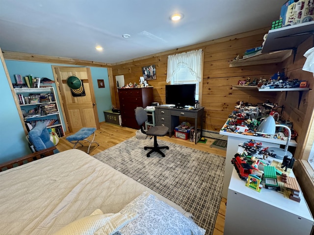 bedroom with wooden walls, a baseboard heating unit, wood finished floors, and recessed lighting