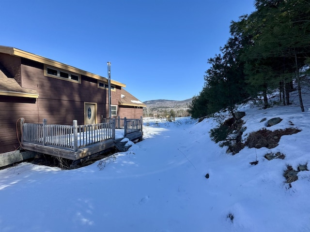 snowy yard featuring a wooden deck