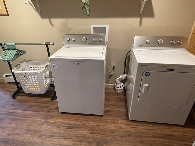 laundry room with laundry area, baseboards, dark wood finished floors, washing machine and clothes dryer, and a baseboard heating unit