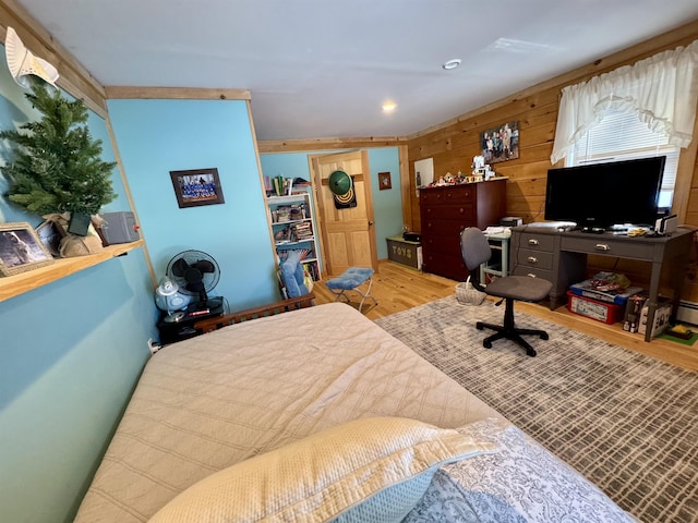 bedroom with wood walls and wood finished floors