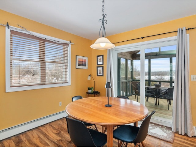 dining area with a baseboard radiator and wood finished floors