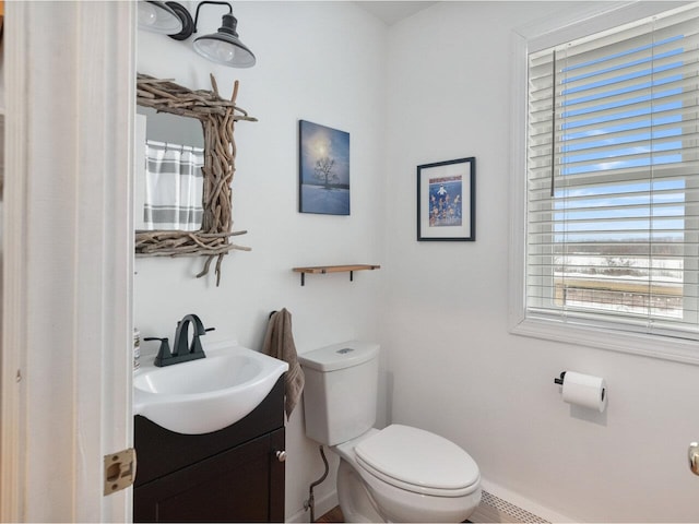 bathroom featuring vanity, toilet, and baseboards