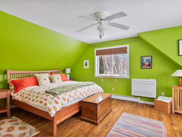 bedroom featuring a ceiling fan, a baseboard radiator, vaulted ceiling, and hardwood / wood-style flooring