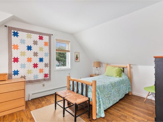 bedroom featuring lofted ceiling, a baseboard radiator, and hardwood / wood-style flooring