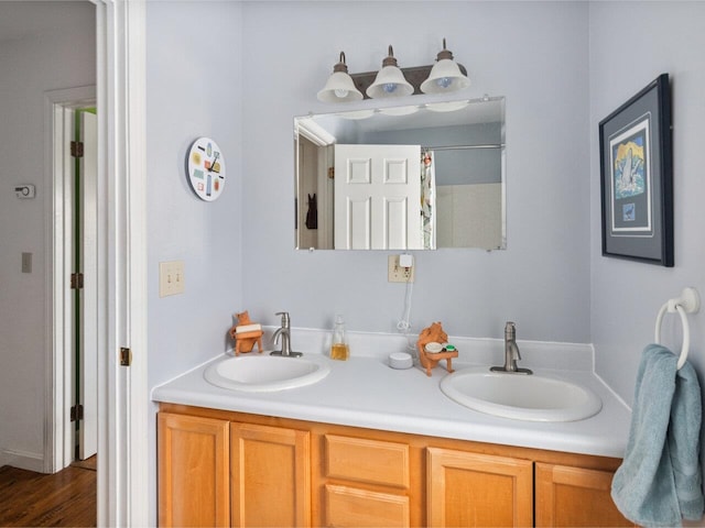 bathroom with double vanity, curtained shower, and a sink