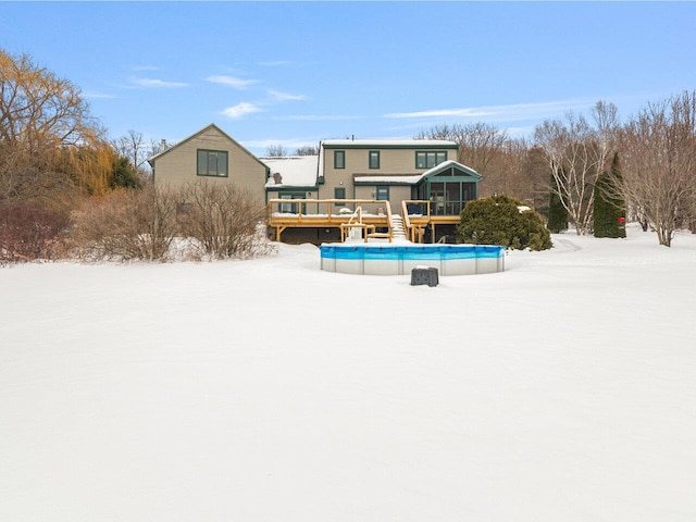 snow covered pool featuring a sunroom, an outdoor pool, and a wooden deck