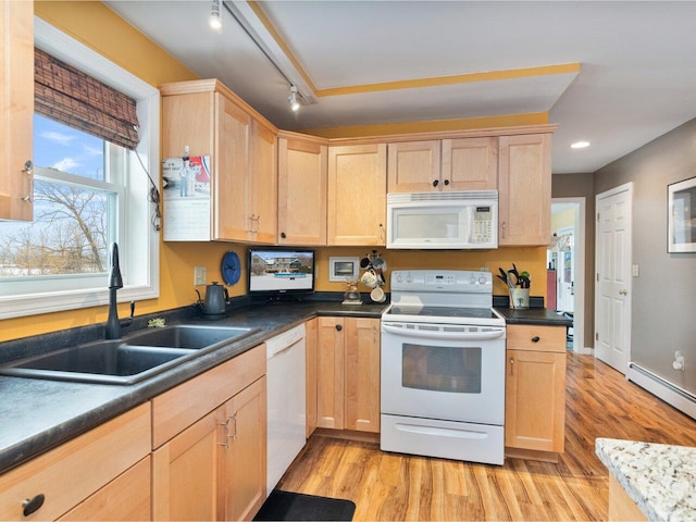 kitchen featuring dark countertops, white appliances, light brown cabinets, and a sink