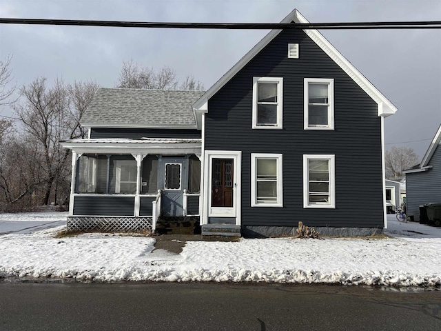 view of front of property featuring a shingled roof and a sunroom